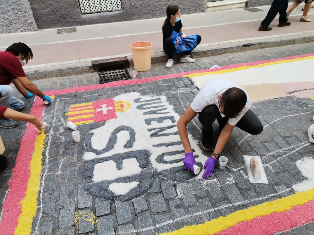Varios jóvenes realizando la alfombra de sal este viernes en la calle Merced Varios jóvenes realizando la alfombra de sal este viernes en la calle Merced