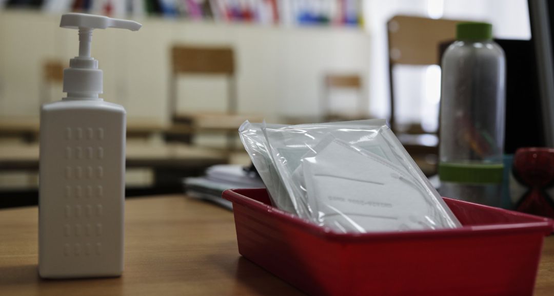 Mascarillas y gel desinfectante en la mesa del profesor de un aula. Mascarillas y gel desinfectante en la mesa del profesor de un aula.