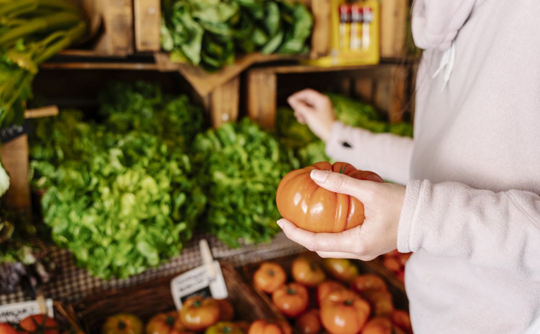 Una persona compra verduras en una frutería. Una persona compra verduras en una frutería.