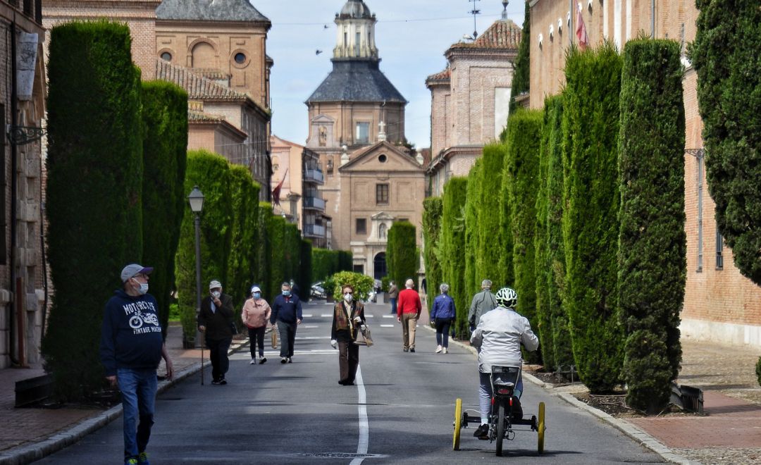 Vecinos de Alcalá de Henares andando por la calzada de la calle Colegios Vecinos de Alcalá de Henares andando por la calzada de la calle Colegios
