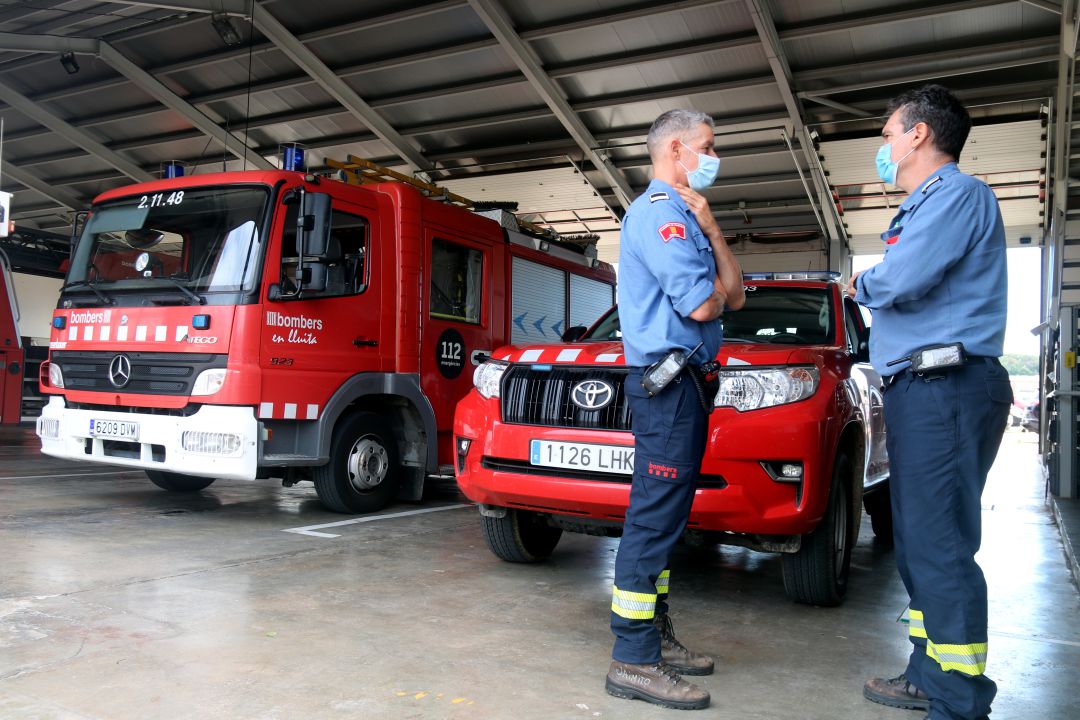 Dos bombers davant la cotxera del parc de Girona Dos bombers davant la cotxera del parc de Girona