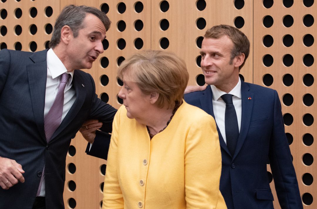 El primer ministro griego, EKyriakos Mitsotakis saluda al presidente francés, Emmanuel Macron, y a la canciller alemana, Angela Merkel, en la sesión plenaria de la cumbre UE-Balcanes. El primer ministro griego, EKyriakos Mitsotakis saluda al presidente francés, Emmanuel Macron, y a la canciller alemana, Angela Merkel, en la sesión plenaria de la cumbre UE-Balcanes.