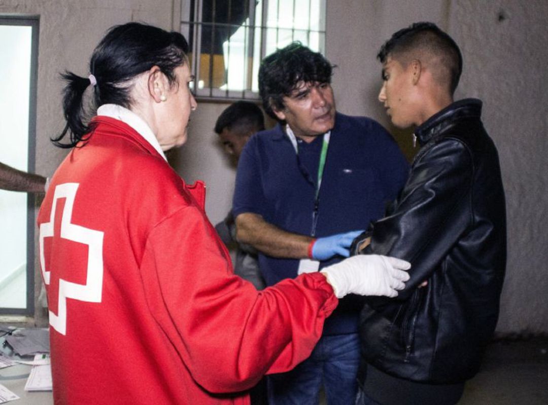 Voluntarios de Cruz Roja atiende a uno de los inmigrantes en el puerto de Motril Voluntarios de Cruz Roja atiende a uno de los inmigrantes en el puerto de Motril
