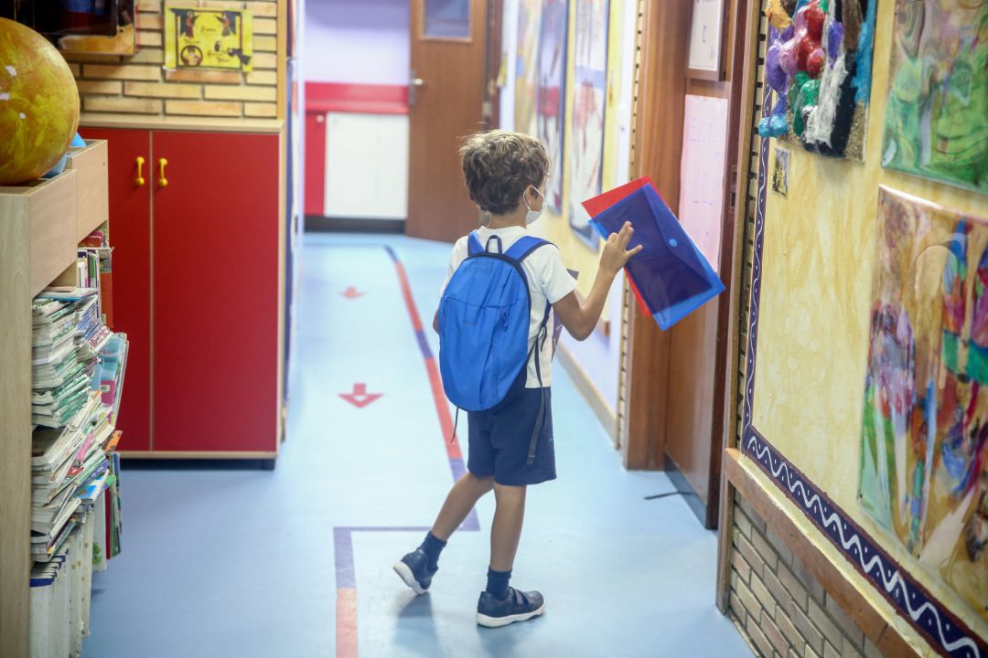 Un niño entra a una clase de un colegio Un niño entra a una clase de un colegio