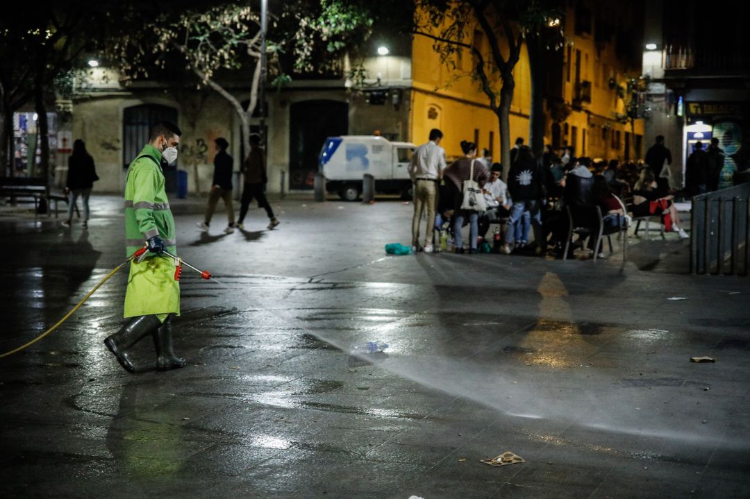 Efectivos de limpieza acondicionan una plaza en Barcelona mientras varios jóvenes se encuentran de botellón Efectivos de limpieza acondicionan una plaza en Barcelona mientras varios jóvenes se encuentran de botellón
