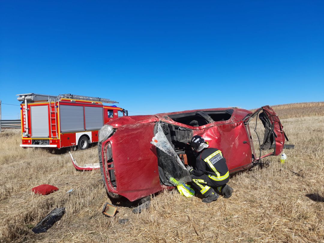 Un bombero inspecciona el interior del vehículo accidentado Un bombero inspecciona el interior del vehículo accidentado