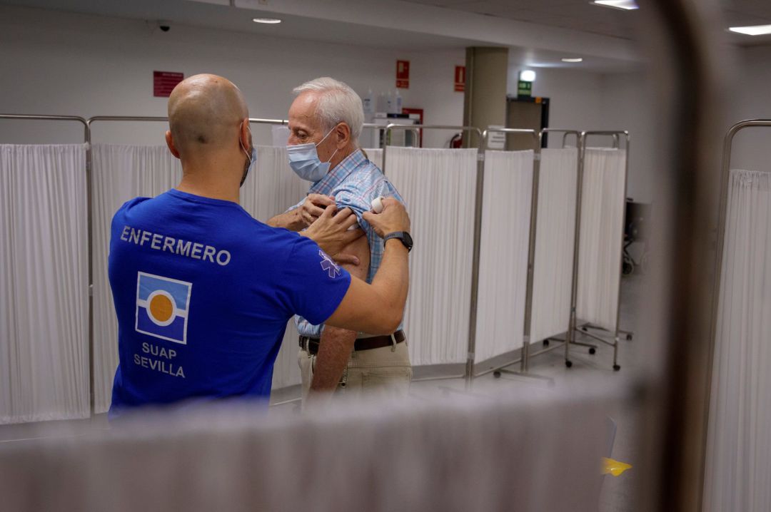 Un enfermero inocula la tercera dosis de la vacuna contra la covid-19 a un hombre mayor de 70 años que se ha iniciado hoy lunes, en la Facultad de Derecho de la capital andaluza, la campaña en la que también se les administrará la vacuna de la gripe Un enfermero inocula la tercera dosis de la vacuna contra la covid-19 a un hombre mayor de 70 años que se ha iniciado hoy lunes, en la Facultad de Derecho de la capital andaluza, la campaña en la que también se les administrará la vacuna de la gripe