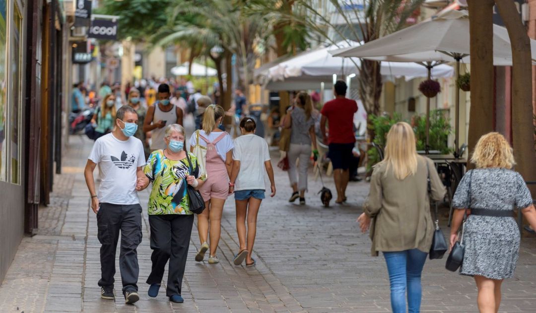 Personas con mascarilla paseando por la calle. Personas con mascarilla paseando por la calle.