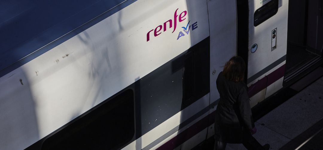 Un viajero junto a un tren del AVE Un viajero junto a un tren del AVE