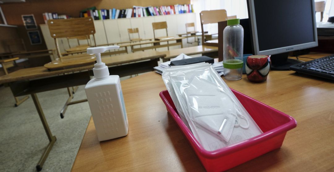 Mascarillas y gel desinfectante en la mesa del profesor de un aula. Mascarillas y gel desinfectante en la mesa del profesor de un aula.