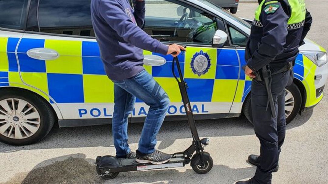 Un agente sanciona a un hombre con patinete. Un agente sanciona a un hombre con patinete.