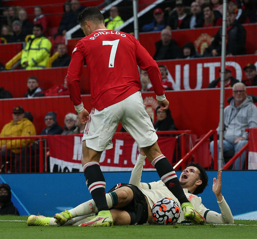 Cristiano Ronaldo propinando una patada al balón protegido por Jones Cristiano Ronaldo propinando una patada al balón protegido por Jones
