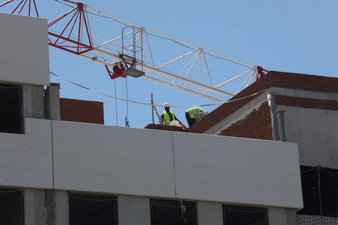 Archivo - Dos obreros trabajan en la construcción de un edificio Archivo - Dos obreros trabajan en la construcción de un edificio
