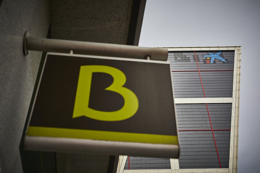 Un cartel con el símbolo de Bankia delante del logo de Caixabank tras su sustitución por el de Bankia en las torres Kio, en Madrid (España). Un cartel con el símbolo de Bankia delante del logo de Caixabank tras su sustitución por el de Bankia en las torres Kio, en Madrid (España).
