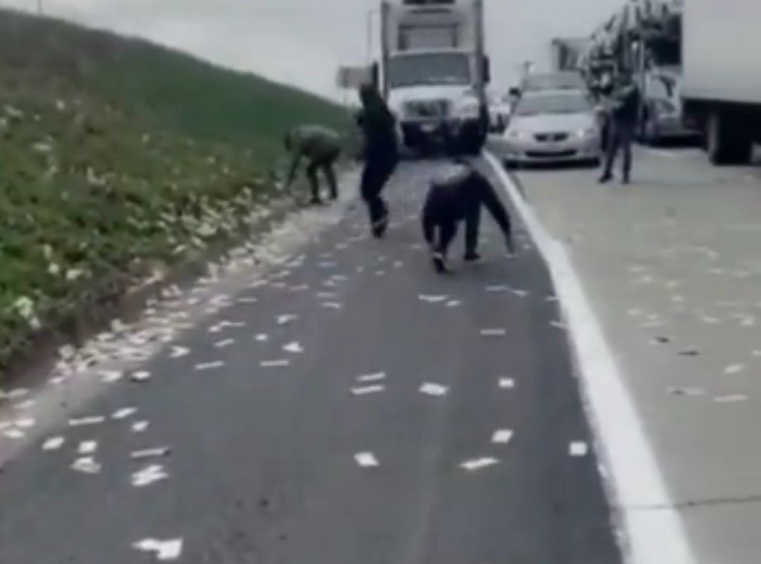 Conductores recogen dinero del suelo que cae de un coche blindado. Conductores recogen dinero del suelo que cae de un coche blindado.