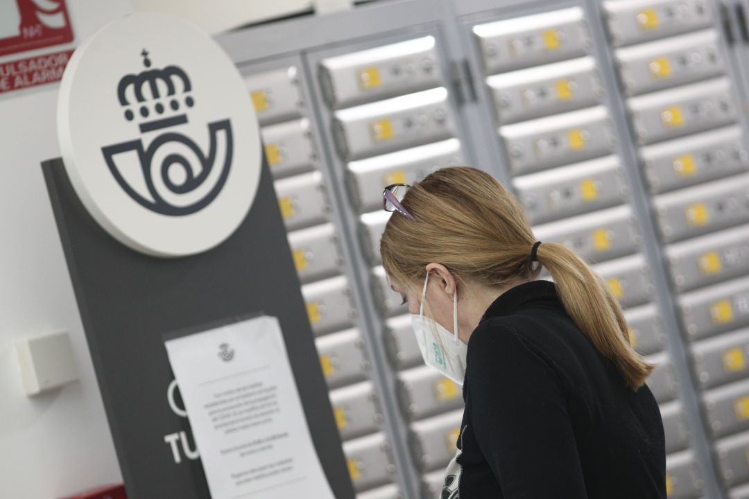 Una mujer en una oficina de Correos. Una mujer en una oficina de Correos.