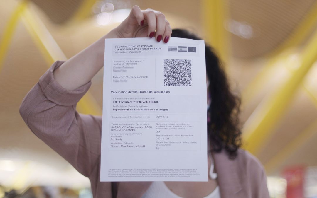 Una mujer muestra el certificado COVID Digital de la Unión Europea. Una mujer muestra el certificado COVID Digital de la Unión Europea.