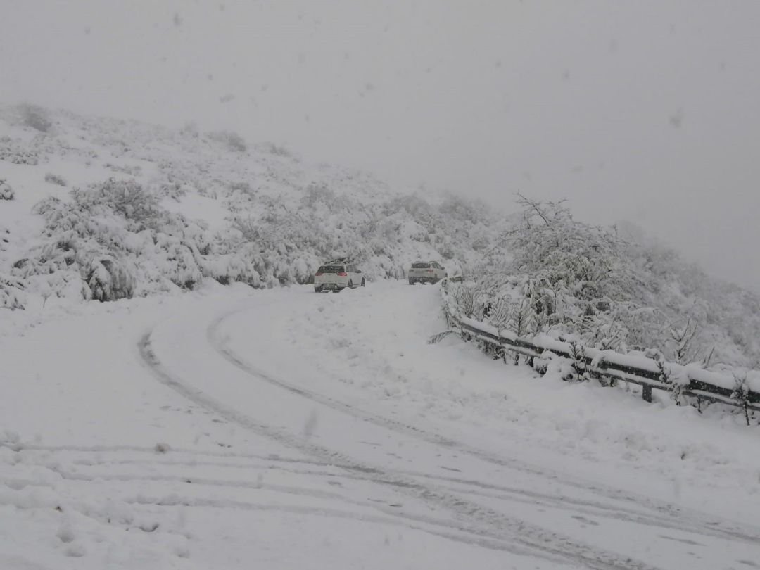 Nieve con dos vehículos en la carretera Nieve con dos vehículos en la carretera