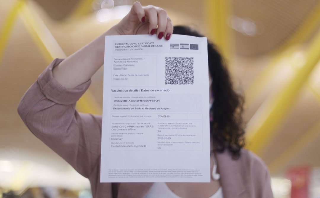 Una mujer muestra el certificado COVID Digital de la Unión Europea. Una mujer muestra el certificado COVID Digital de la Unión Europea.