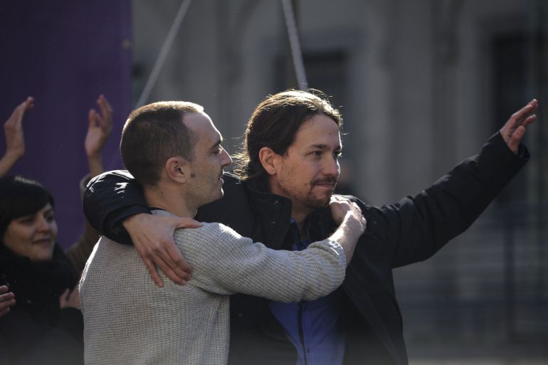 Spain's anti-austerity party Podemos leader Pablo Iglesias (R) and Madrid chief candidate Luis Alegre embrace during the closing rally of a political campaign for the municipal elections in Madrid on February 8, 2015.   AFP PHOTO / PEDRO ARMESTRE