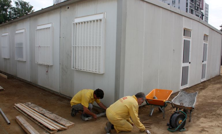 Operaris treballant en el barracó nou de l'escola Paco Candel de l'Hospitalet del Llobregat