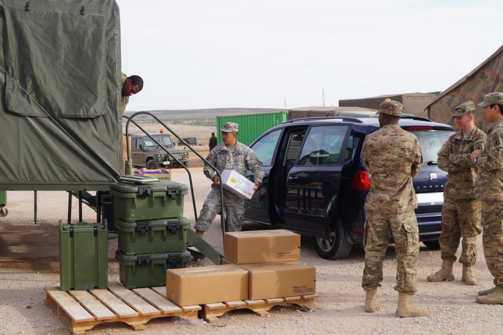 Un militar descarga una caja con comida en la cocina del campamento Un militar descarga una caja con comida en la cocina del campamento