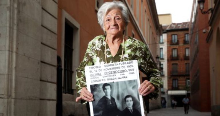 Ascensión Mendieta portando un cartel con una fotografía de su padre