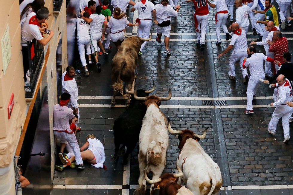 Una mujer cae al suelo ante los toros. Una mujer cae al suelo ante los toros.
