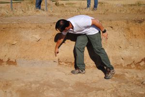 El arqueólogo explica los extratos de tierra acumulada en distintas épocas.