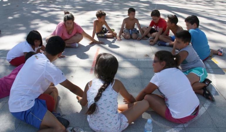 Un grup de nens fent rotllana en el campament d'urbà organitzat al barri de Baró de Viver de Barcelona.