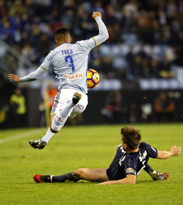 El delantero del Celta de Vigo Theo Bondonga (i) pugna por un balón con el defensa del Málaga Llorente durante el encuentro correspondiente a la decimoséptima jornada de primera división, que disputan esta noche en el estadio de Balaídos, en Vigo.
