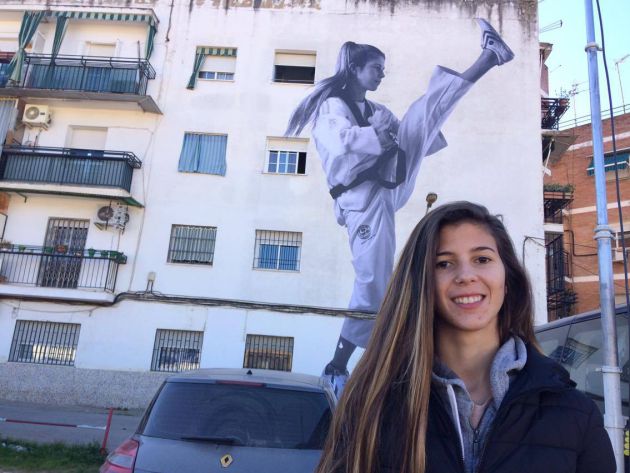 La deportista , María Ballesteros, junto a su mural en la Acera de Granada