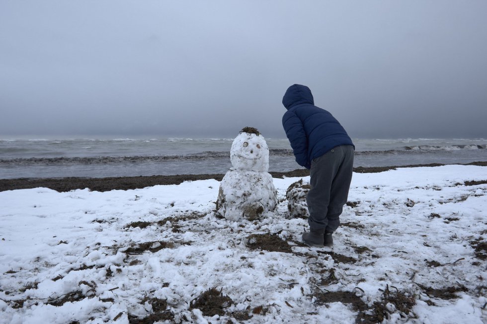 Un niño juega con un muñeco de nieve en la playa de Les Marines, en Denia. Un niño juega con un muñeco de nieve en la playa de Les Marines, en Denia.
