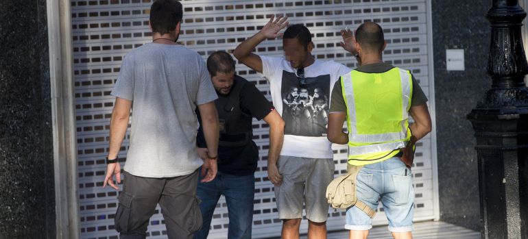 Efectivos policiales registran a un hombre en el lugar del atentado ocurrido hoy en las Ramblas de Barcelona