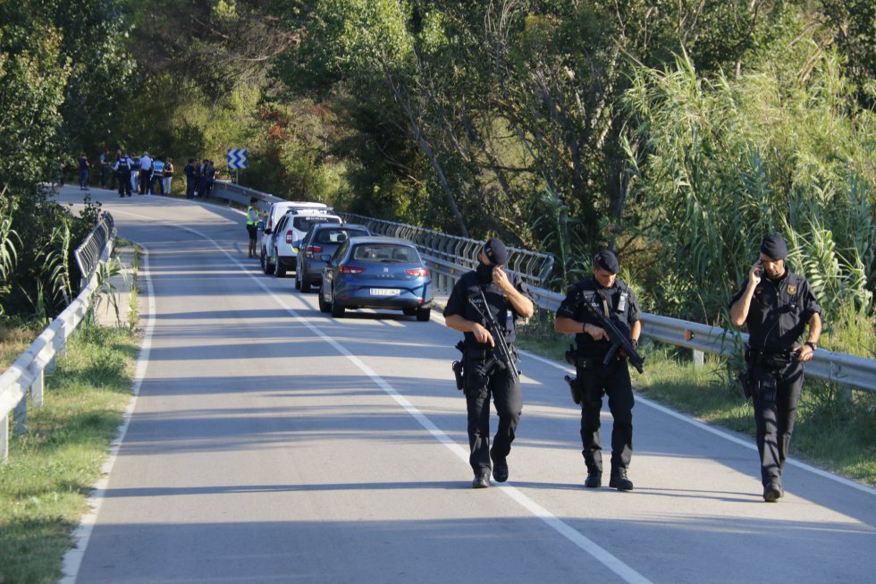 Tres agentes de los Mossos d'Esquadra caminan por la carretera de Subirats. Tres agentes de los Mossos d'Esquadra caminan por la carretera de Subirats.