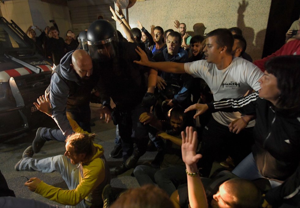 Los concentrados protestan por el registro que lleva a cabo la Guardia Civil por orden judicial en la consellería gritando consignas a favor del referéndum del 1 de octubre.