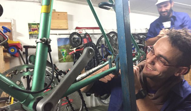 Antonio reparando una bicicleta en el taller.