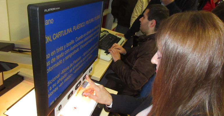 Una usuaria de ONCE utiliza un ordenador adaptado en la nueva Tifloteca.