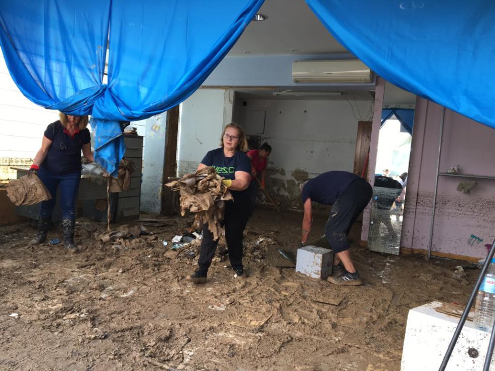 Vecinos de Arganda limpian en una tienda de ropa infantil arrasada por el agua. Vecinos de Arganda limpian en una tienda de ropa infantil arrasada por el agua.