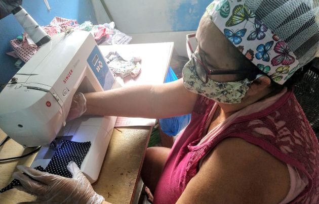 Una mujer elabora una mascarilla para evitar el contagio del coronavirus en las comunidades indígenas del Amazonas