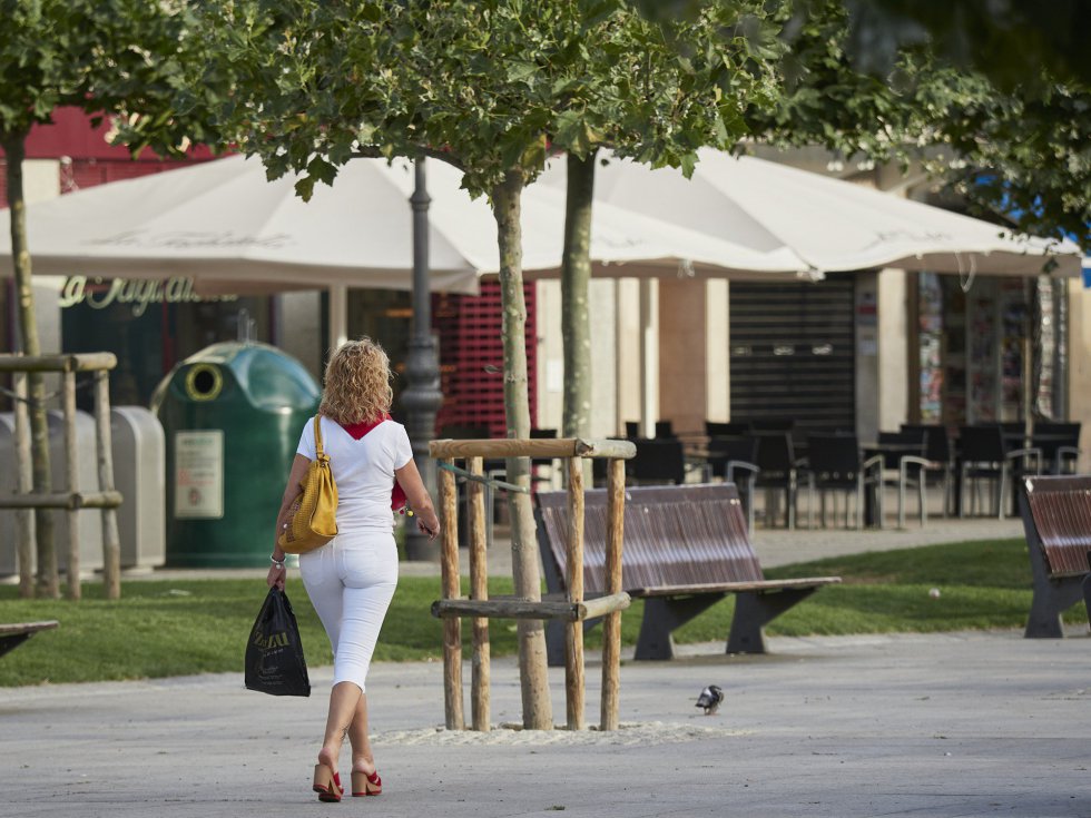 na mujer vestida de blanco y con pañuelo rojo (típicos de San Fermín) camina por el casco antiguo a primera hora de la mañana na mujer vestida de blanco y con pañuelo rojo (típicos de San Fermín) camina por el casco antiguo a primera hora de la mañana