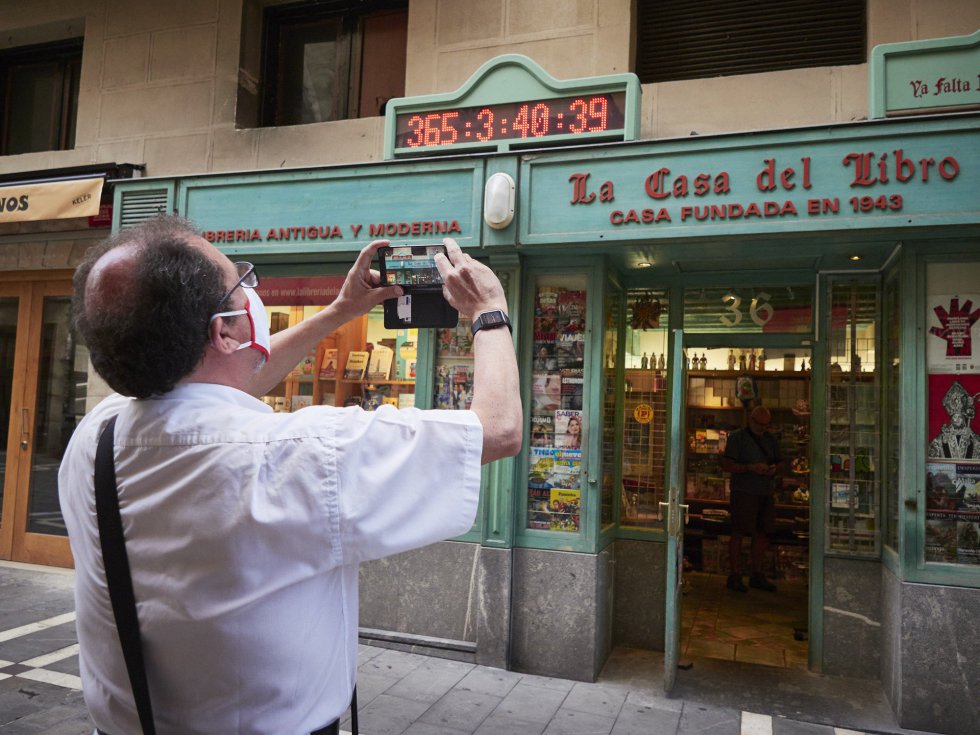 Un hombre con mascarilla y vestido de blanco con pañuelo rojo -los colores de San Fermín- toma fotos en el casco antiguo a primera hora de la mañana, Un hombre con mascarilla y vestido de blanco con pañuelo rojo -los colores de San Fermín- toma fotos en el casco antiguo a primera hora de la mañana,