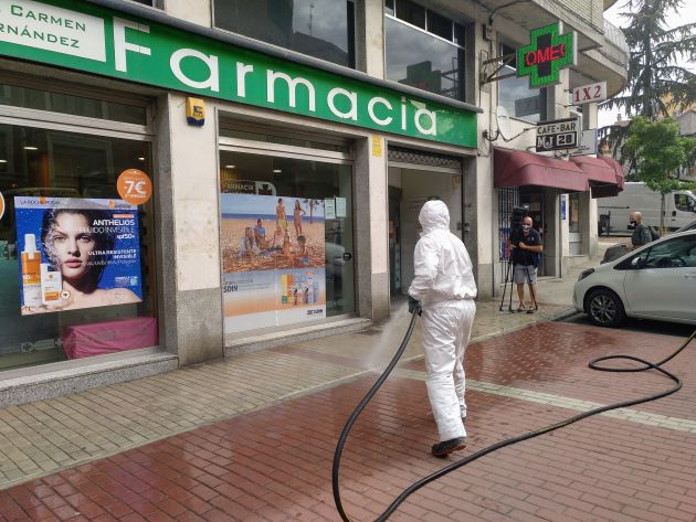 Un operario de FCC desinfecta el acceso a una farmacia en el Paseo de San Roque (Ávila)