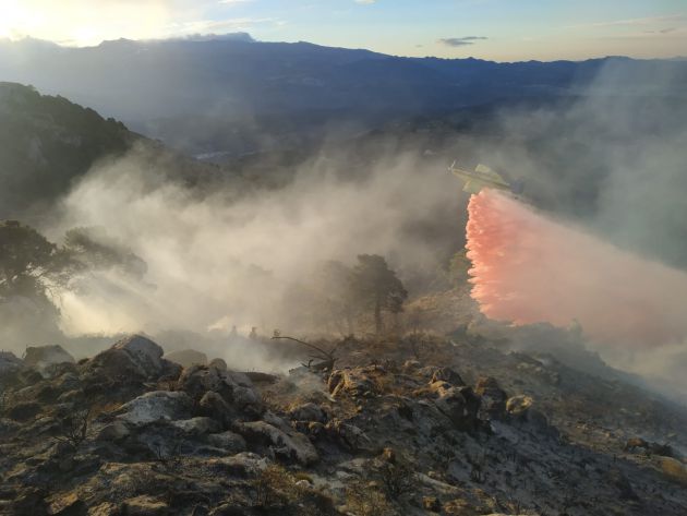 Un avión del INFOCA descarga agua sobre el incendio forestal del paraje Cruz de Víznar, en el parque natural Sierra de Huétor, en Granada