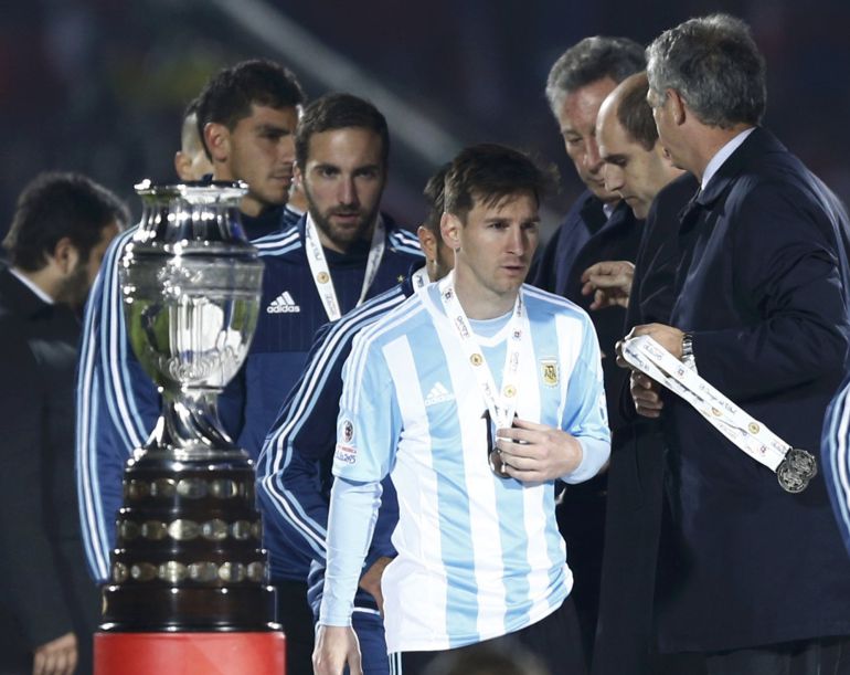 Argentina's Lionel Messi walks past the trophy after losing to Chile in the Copa America 2015 final soccer match at the National Stadium in Santiago, Chile, July 4, 2015. REUTERS/Marcos Brindicci