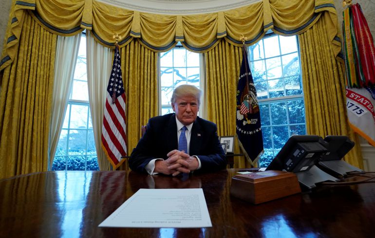 U.S. President Donald Trump sits at the Resolute Desk  during an interview with Reuters at the White House in Washington