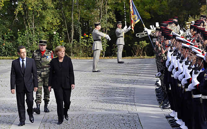 El presidente francés, Nicolas Sarkozy y la Canciller alemana Angela Merkel pasan revista a las tropas  en la inauguración del Memorial Charles de Gaulle