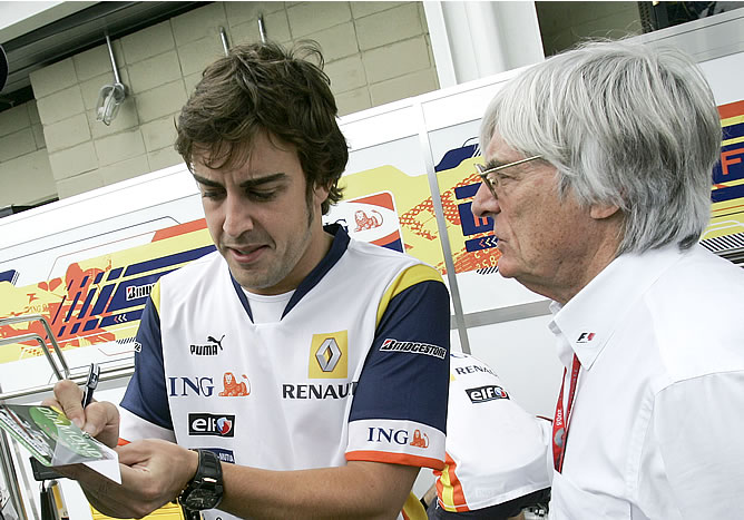 Fernando Alonso firmando autógrafos en presencia de Bernie Ecclestone