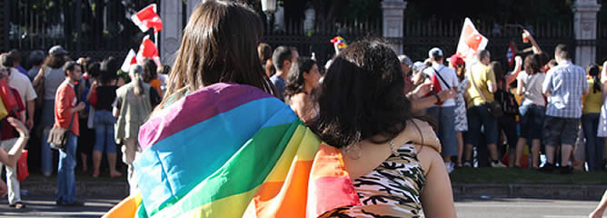 Dos lesbianas observan el paso de la marcha del 'Orgullo Gay' del pasado 7 de julio