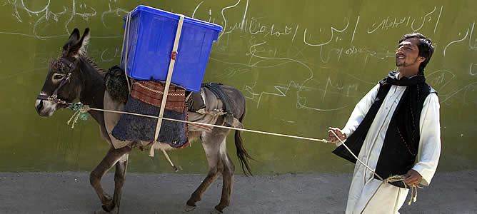 Un hombre lleva una urna en su burro hasta el centro electoral de una zona rural de Afganistán
